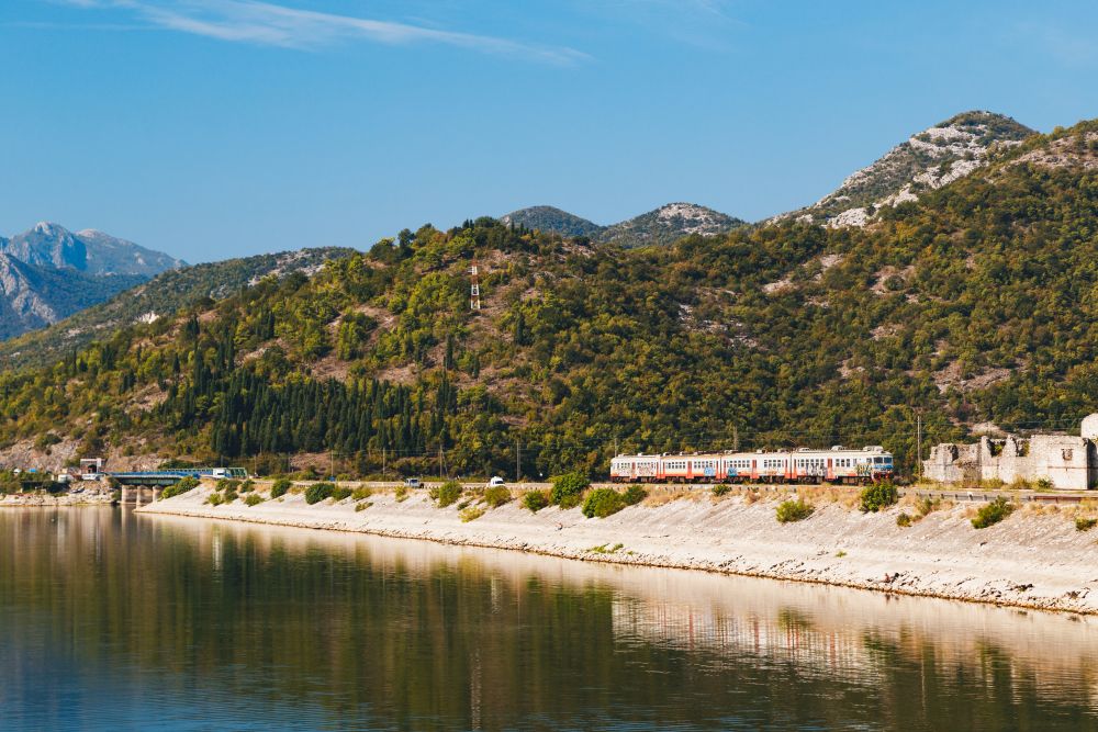 View at a dam with a train at railway Bar – Belgrade at Lake Skadar in Montenegro, National Park, famous tourist attraction and the largest lake in Southern Europe.